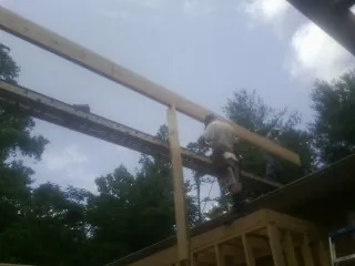 Carpenter setting a ridge beam over a new addition frame — Ice Dam Removal by Roofing Brothers in Flanders