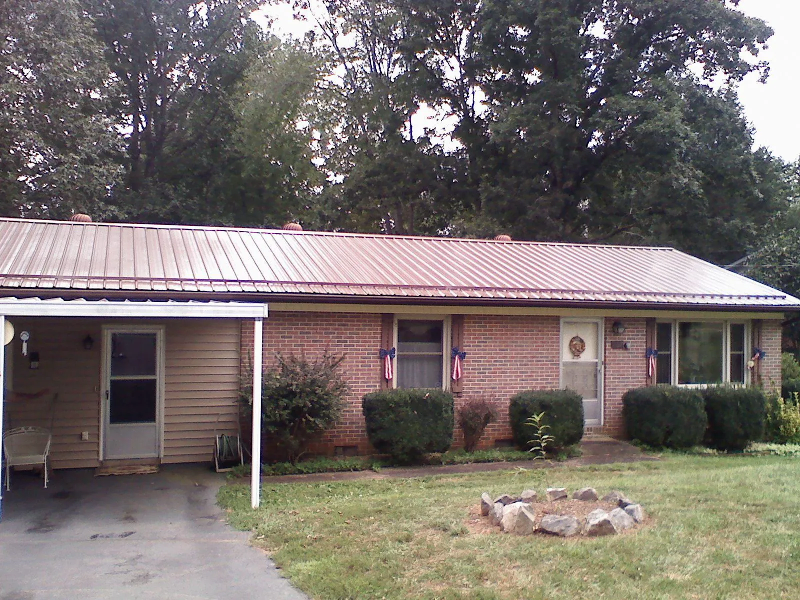 Bronze metal roof and carport on a brick ranch home — Roof Repair work by our crew in Flanders